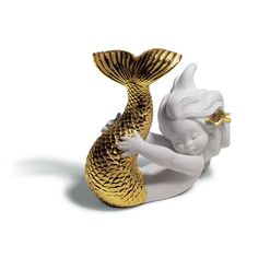 a gold and white figurine with a mermaid tail