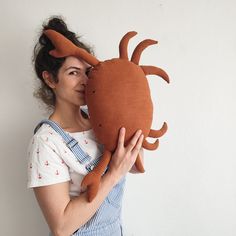 a woman holding a stuffed crab in front of her face