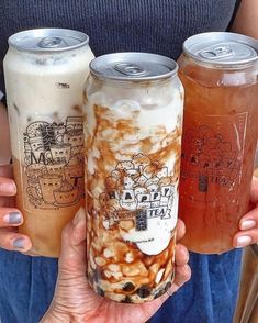 three different types of beverages are being held in their hands, one is filled with liquid and the other has food on it