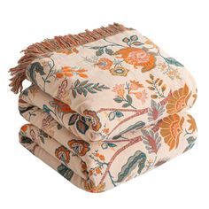 two blankets with floral designs and fringes are folded up on top of each other