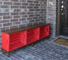 a red cabinet sitting next to a brick wall