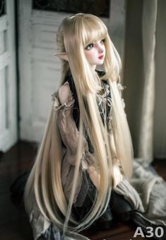 a doll with long blonde hair sitting on the floor