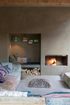 a living room filled with furniture and a fire place in the middle of it's wall