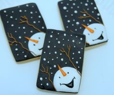 three decorated cookies sitting on top of a white plate