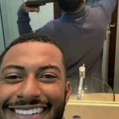 a man is smiling in front of a mirror