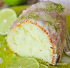 a close up of a piece of cake on a plate with limes around it