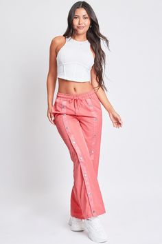 Off-duty vibes! Our Snap Wide Leg Pant is the perfect combination of parachute pants and track pants. These are great for days you want to rock a comfy and sporty look, but with a streetwear vibe. Featuring snap buttons centered along the fronts and backs of each leg for design and functional purposes. Not only do they look super trendy and chic, but you can unsnap or snap them to adjust the pants to the width of your liking. Also designed with an elastic waistband and drawstring for ultimate co Summer Sports Wide-leg Parachute Pants, Spring Athleisure Cargo Pants For Streetwear, Spring Athleisure Streetwear Cargo Pants, Trendy Sports Pants, Trendy Streetwear Parachute Pants With Elastic Waistband, Trendy Parachute Pants For Streetwear, Sporty Spring Streetwear Cargo Pants, Sporty Parachute Pants For Summer Streetwear, Sporty Summer Parachute Pants For Streetwear