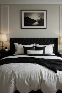 a bed with black and white comforter in a bedroom next to two lamps on either side of the bed