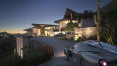 a car is parked in front of a large house at night with the lights on