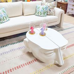 a living room filled with white furniture and lots of pillows on top of it's sides