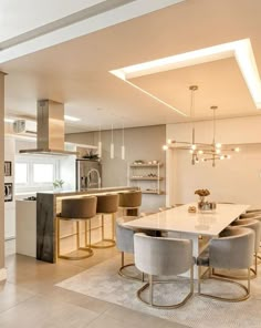 a dining room and kitchen area with modern lighting