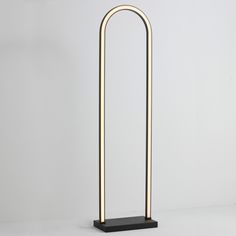 a black and gold lamp on a white surface