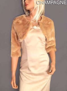 a female mannequin wearing a dress and fur collared jacket, standing in front of a gray background