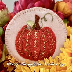 a close up of a pumpkin on a table with flowers