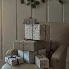 a stack of wrapped presents sitting on top of a chair