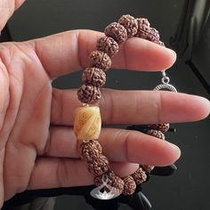 Calm your body and mind with this handmade Rudraksha Mala bracelet. Made with 5 Muhki Rudraksha beads and a carved Tibetan Yak Bone focal bead. This beaded bracelet was designed as a powerful spiritual accessory, filled with positive energy.  Rudraksha seeds are said to safeguard the wearer from negative energies and can help with clarity of body, mind, and thought for enhanced consciousness. Their calming effects are often used to help reduce blood pressure and overall health.  SPIRITUAL PROPERTIES OF THE BRACELET Good Luck, Prosperity, and Abundance. Purification and Cleansing. Concentration and Emotional Balance. Peace, Tranquility and Calmness About * Handmade Bracelet  * 5 Mukhi Rudraksha Bracelet * Select Your Size * Available with 10 mm Rudraksha Seeds * Carved bone barrel bead meas Spiritual Handmade Beaded Bracelet With Oval Beads, Handmade Spiritual Beaded Bracelet With Oval Beads, Spiritual Brown Beaded Bracelet With Oval Beads, Handmade Holistic Bracelets With Round Beads, Spiritual Brown Beaded Bracelets With Oval Beads, Spiritual Rosary Bracelet With Polished Beads, Adjustable Stretch Bracelet With Large Beads For Meditation, Hand Wrapped Spiritual Bead Bracelet, Hand-strung Oval Bead Bracelets For Gifts