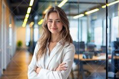 a woman standing in an office with her arms crossed