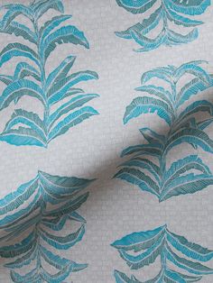 a blue and white wallpaper with large leaves on the back of it's surface