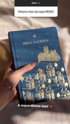 a person holding a book in their hand on top of a white sheet with the words biblia sagrada written above it