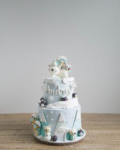 a three tiered cake decorated with animals and snowflakes