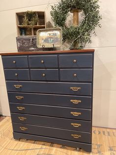 an old dresser has been painted dark blue with gold handles and brass knobs on it