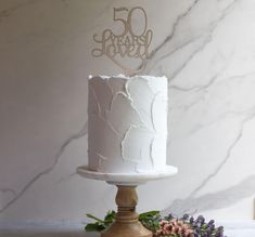 a white cake sitting on top of a wooden stand