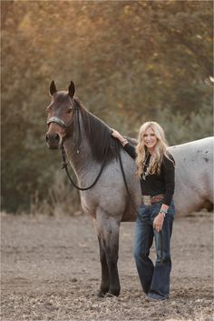 a woman is standing next to a horse