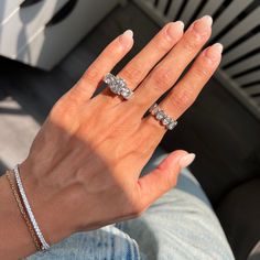 a woman's hand with three diamond rings on her left and two diamonds on her right