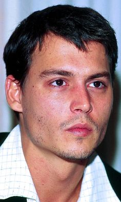 a close up of a person wearing a tie and looking at the camera with a serious look on his face