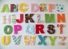 the letters are made up of different fabrics and fabric pieces, all in bright colors