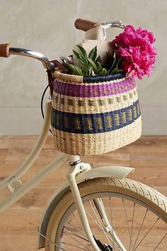 a basket with flowers on the back of a bicycle