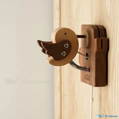 a wooden phone mounted to the side of a door with a bird on it's back