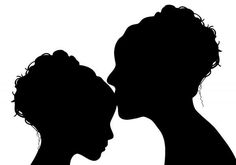 the silhouette of two women kissing each other