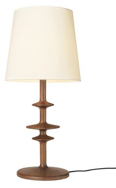 a table lamp with a white shade on it and a cord plugged into the base