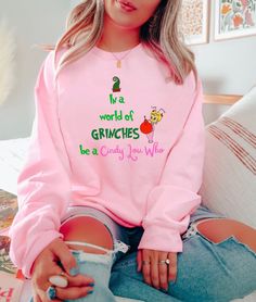 "In A World Full Of Griches Be A Cindy Lou Who Shirt, Christmas Shirt, Holiday Shirt, Grich Shirt, Cindy Lou Who, Christmas T-Shirt, Grich. Available in white/ash/sand/light blue/light pink. Please refer to size chart for measurements. ♡ HOW TO ORDER 1️⃣ Swipe to all of the pictures. 2️⃣ Select style and size from drop down menus. 3️⃣ Select shirt colors from drop down menus. 4️⃣ Select quantity and click \"add to cart\". 5️⃣ For every single shirt you have to repeat every step.. ♡ MATERIAL INFO * This updated unisex features design with superior combed ring-spun cotton. * Ultra Soft * Sideseamed * Retail fit * Unisex sizing * Shoulder taping ♡ PROCESSING TIMES INFO * We ships the order the next day. * Rush options are available at check out. ♡ SHIPPING INFO Standard: 3-5 days to deliver y Grinch Sweatshirt, Grinch Movie, The Grinch Movie, Movie Christmas, Cindy Lou Who, Single Shirt, Christmas Grinch, Cindy Lou, Book Tshirts