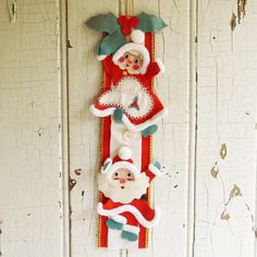 two santa clause ornaments hanging on the side of a door