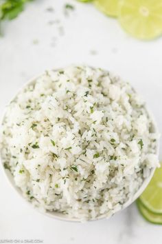 white rice in a bowl with limes around it