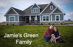 a man and woman sitting in front of a house with a dog on the grass