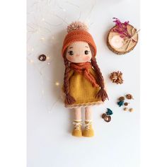 a crocheted doll is sitting next to some buttons and other things on the table