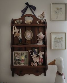 a wooden shelf with pictures and stuffed animals on it