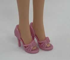 the doll is wearing pink high heels and has her legs bent forward with one foot up