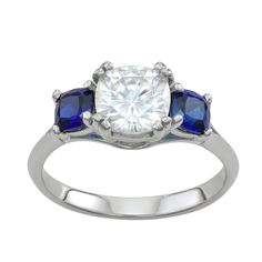 Your style will stand out when you're wearing this striking Charles & Colvard moissanite and sapphire ring. Your style will stand out when you're wearing this striking Charles & Colvard moissanite and sapphire ring. Width: 8 mm Metal: 14k white gold Plating: rhodium Finish: polished Nickel freeSTONE DETAILS Stone type: moissanite, lab-created sapphire Total weight: 3 3/8 ct. Moissanite: 2 ct. Sapphire: 1 3/8 ct. Center stone size: 7.5 mm x 7.5 mm Center stone weight: 2 ct. Shape: cushion Charles And Colvard Moissanite, 3 Stone Rings, White Diamond Ring, Sapphire Wedding, Right Hand Rings, Dream Engagement Rings, Cushion Cut, Womens Jewelry Rings, Polished Nickel