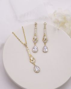 Complete your bridal look with this stunning wedding jewelry set. The sparkling cubic zirconia stones delicately accentuate the bride's natural beauty, adding a touch of elegance and glamor. Featuring an art deco style design, this bridal jewelry set features CZ teardrops accented with a filigree pattern. DETAILS * High quality cubic zirconia.  * Earrings measure 2 inches long. * Necklace is adjustable from 16 inches to 18 inches long, pendant (including bail) measures 2 inches. * Perfect for brides, bridesmaids, prom, or any special occasion. Optional custom cards available for gift giving! * Optional bracelet measures 7 inches long. * Finish: silver, gold or rose gold. * Hypoallergenic, lead-free & nickel-free. SHIPPING * Leaves our facility within 1-3 business days. * Shipping upgrades Gold Cubic Zirconia Bridal Sets, White Cubic Zirconia Bridal Accessories For Wedding, Dazzling Cubic Zirconia Bridal Earrings For Wedding, Dazzling Diamond-accented Jewelry Sets For Wedding, Dazzling Diamond Accented Jewelry Sets For Wedding, Elegant Crystal Bridal Sets For Bride, Classic Cubic Zirconia Bridal Earrings For Wedding, Cubic Zirconia Bridal Set With Sparkling Stones For Wedding, Cubic Zirconia Bridal Set With Prong Setting