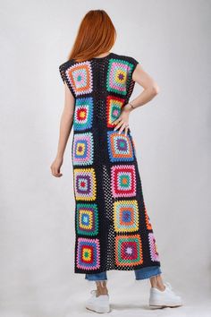 a woman wearing a multicolored crocheted dress