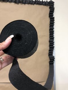 a person is holding a roll of black tape