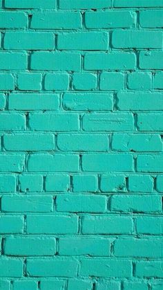 a blue brick wall that is painted bright turquoise