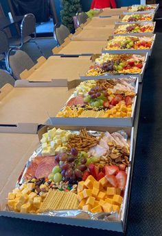 a long table filled with lots of different types of cheeses and fruit on top of it