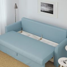 a blue couch sitting next to a table in a living room on top of carpeted floor