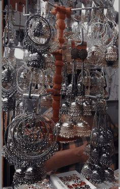 an assortment of silver jewelry on display in a store