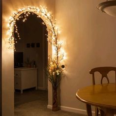 a dining room table with a potted plant and lights on the wall behind it